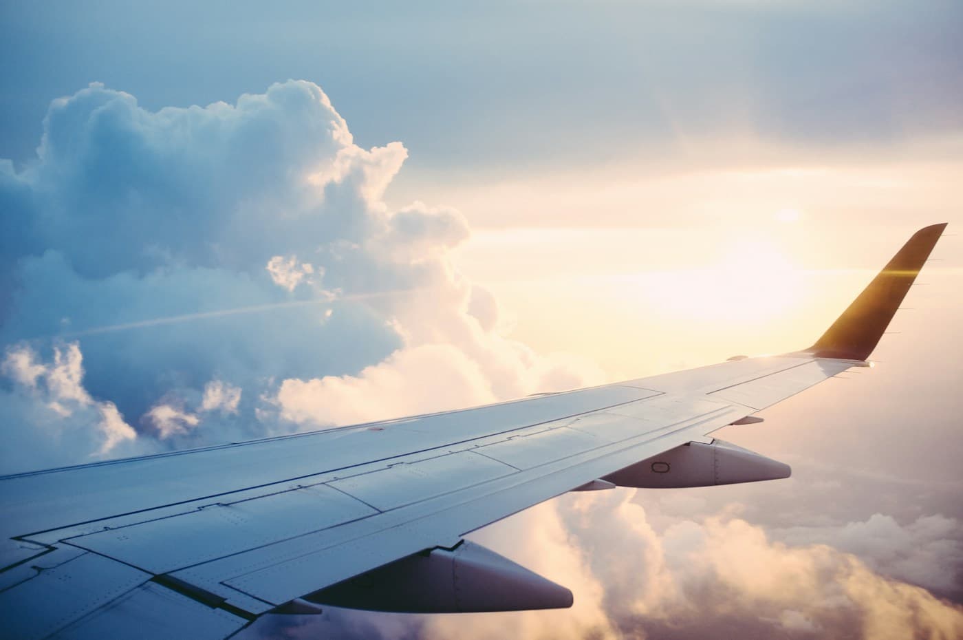 Asa de uma aeronave sobre as nuvens, em fotografia ilustrativa de aviação